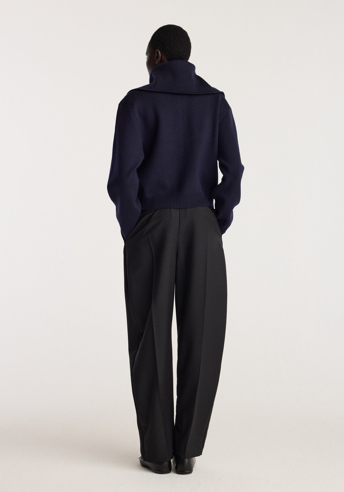 Reversible sailor zip cardigan | navy shown from the back on a model, featuring a high collar, long sleeves, and a relaxed fit with black trousers