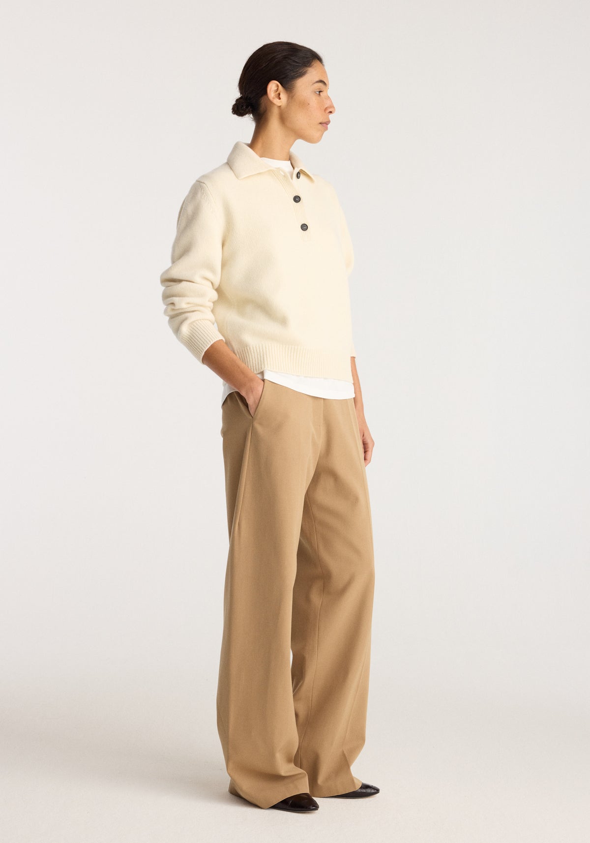 Wool-cashmere polo | cream worn with wide-leg trousers and dark flats on a model in profile against a light studio background