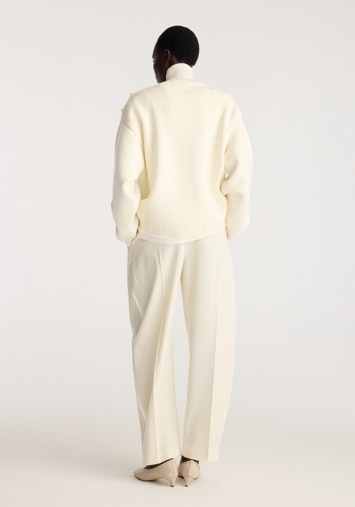 Uneven sailor polo | cream shown from the back on a model with a ribbed collar and hem paired with matching cream trousers