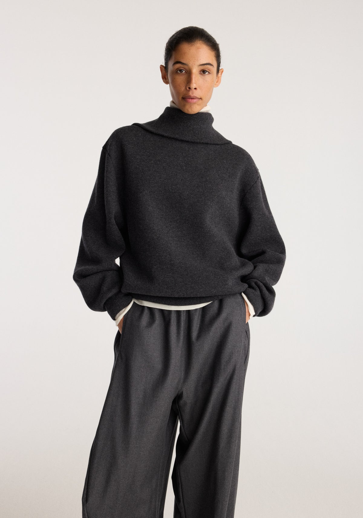 Reversible zipped turtleneck | charcoal shown on a model in a relaxed fit with long sleeves and a high neck paired with dark wide leg trousers