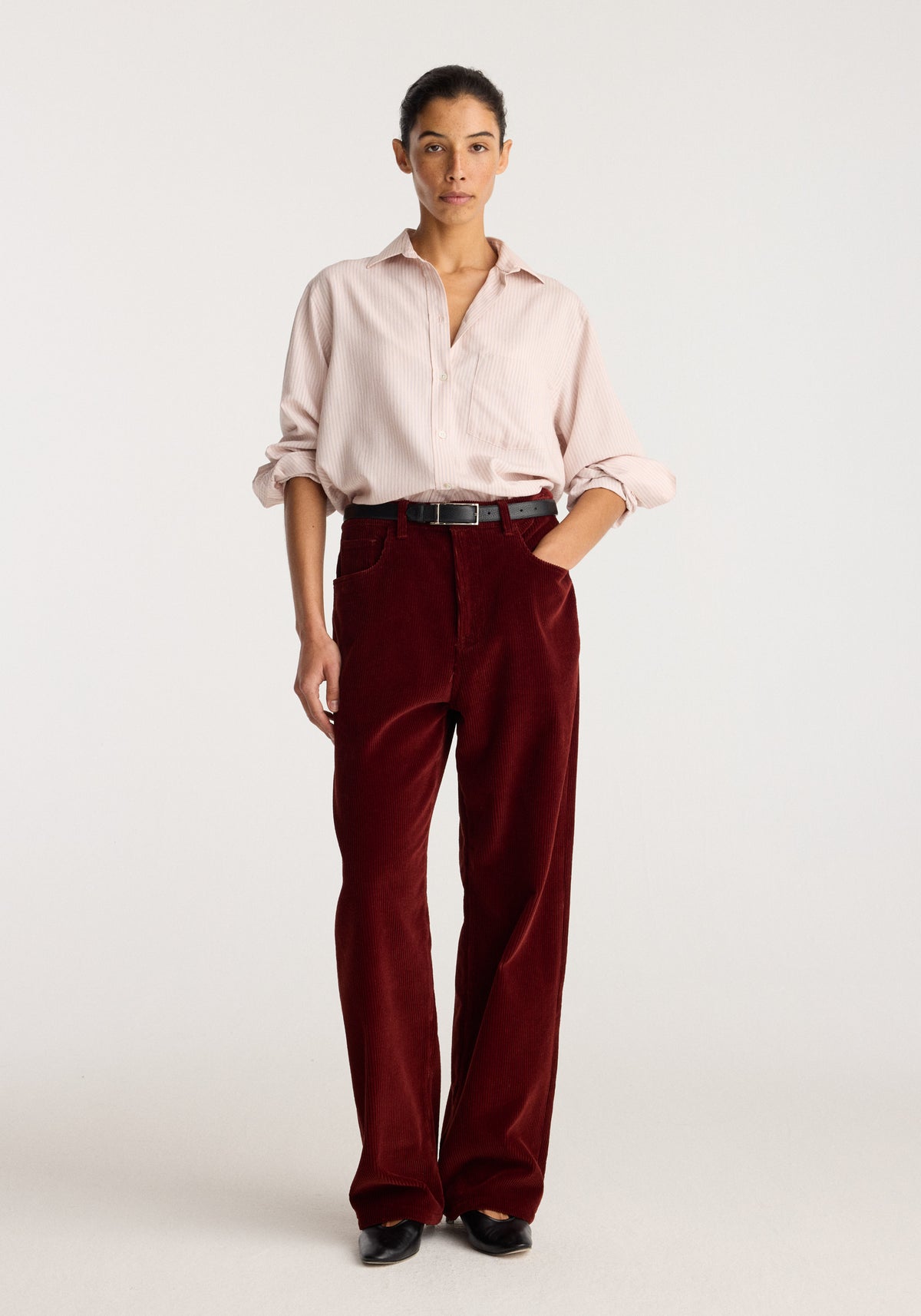 Bruun - Signature baggy corduroy trousers | wine shown on a model with a pale pink shirt and black shoes against a neutral studio background