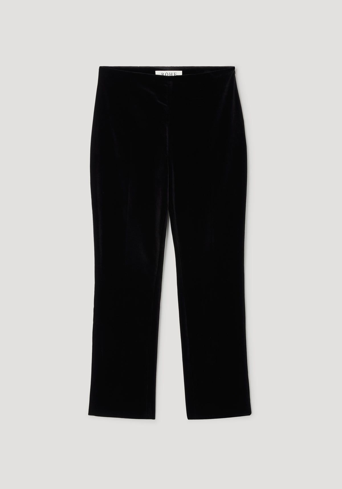 Black cigarette leg velvet tailored trousers laid flat on a light background, showcasing the sleek and smooth texture of the fabric, perfect for a polished look.