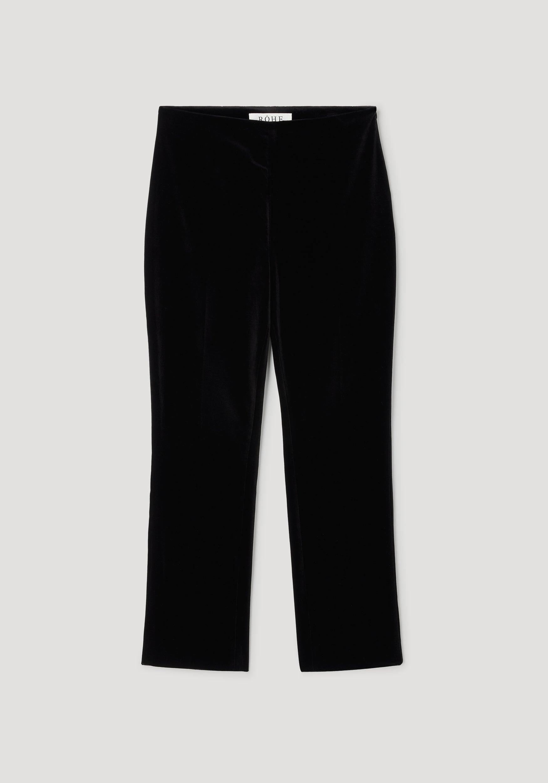 Black cigarette leg velvet tailored trousers laid flat on a light background, showcasing the sleek and smooth texture of the fabric, perfect for a polished look.