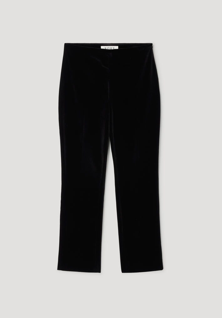 Black cigarette leg velvet tailored trousers laid flat on a light background, showcasing the sleek and smooth texture of the fabric, perfect for a polished look.