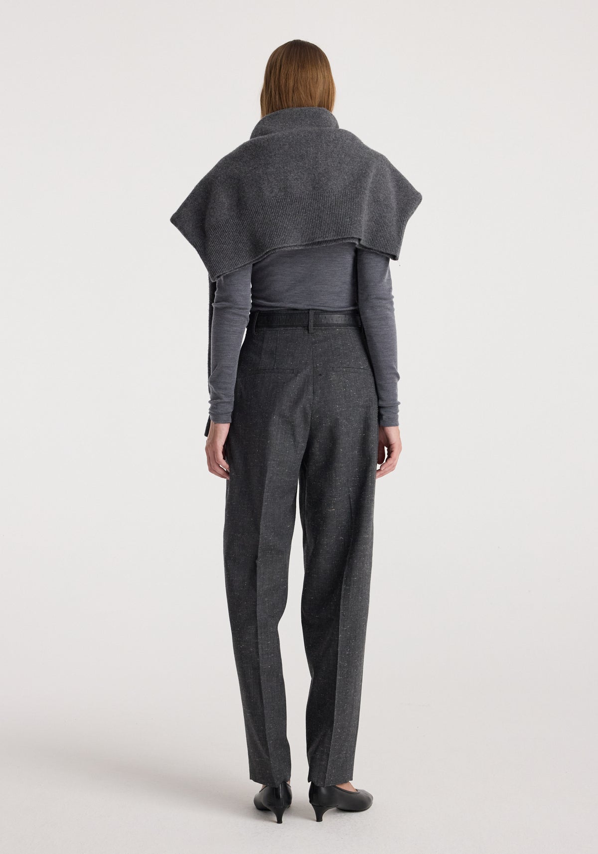 Woman seen from behind wearing Daria - Single pleat straight leg trousers | grey slub paired with a long-sleeve top and a draped shawl over the shoulders.