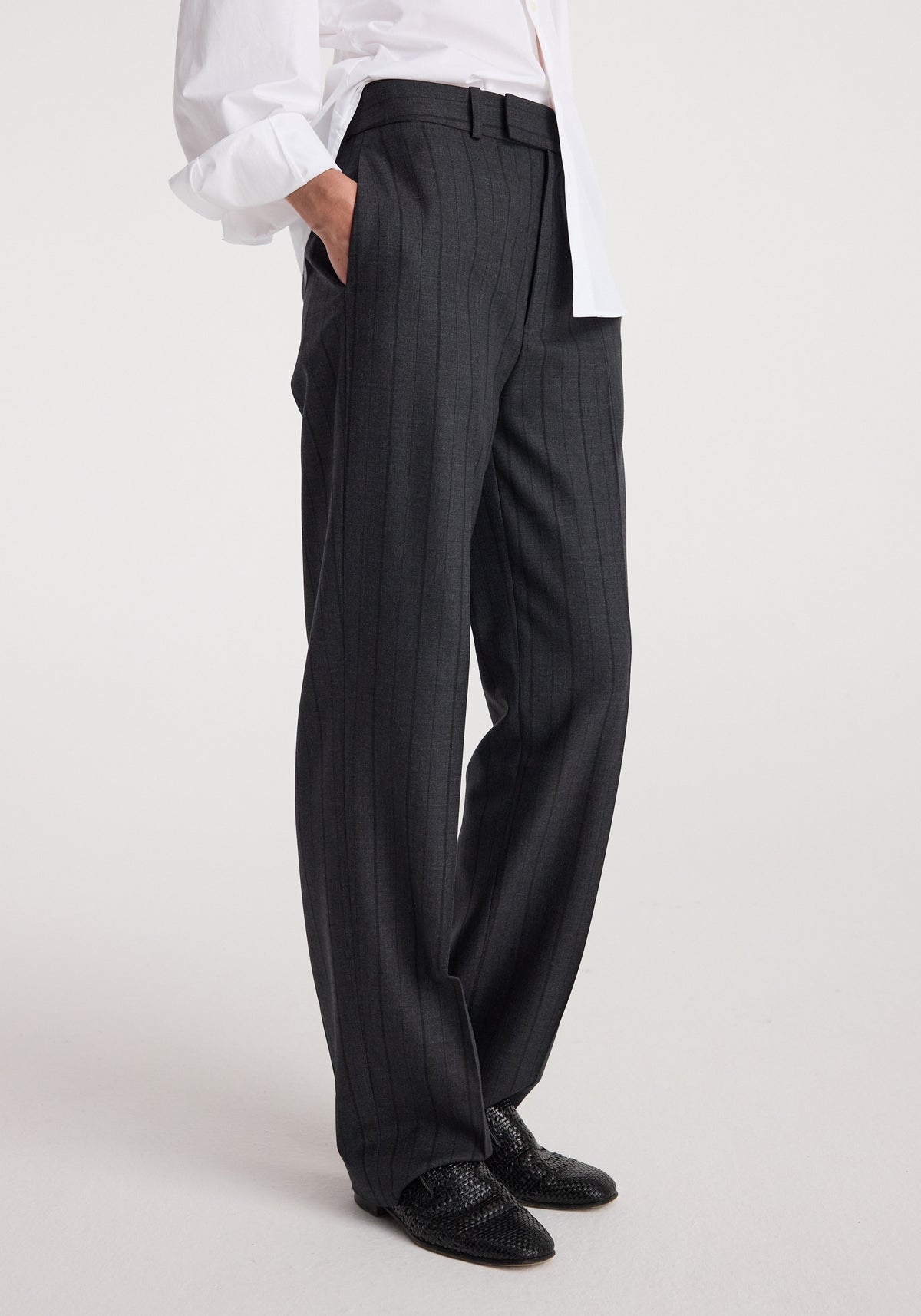 Close-up side view of a person wearing Kee - Straight leg tailored trousers | charcoal stripe paired with black woven shoes and a white shirt.