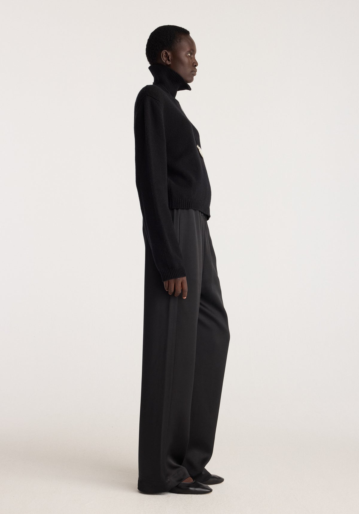Relaxed fit satin trousers | black shown in side profile on a model with a fluid wide leg and softly draped silhouette