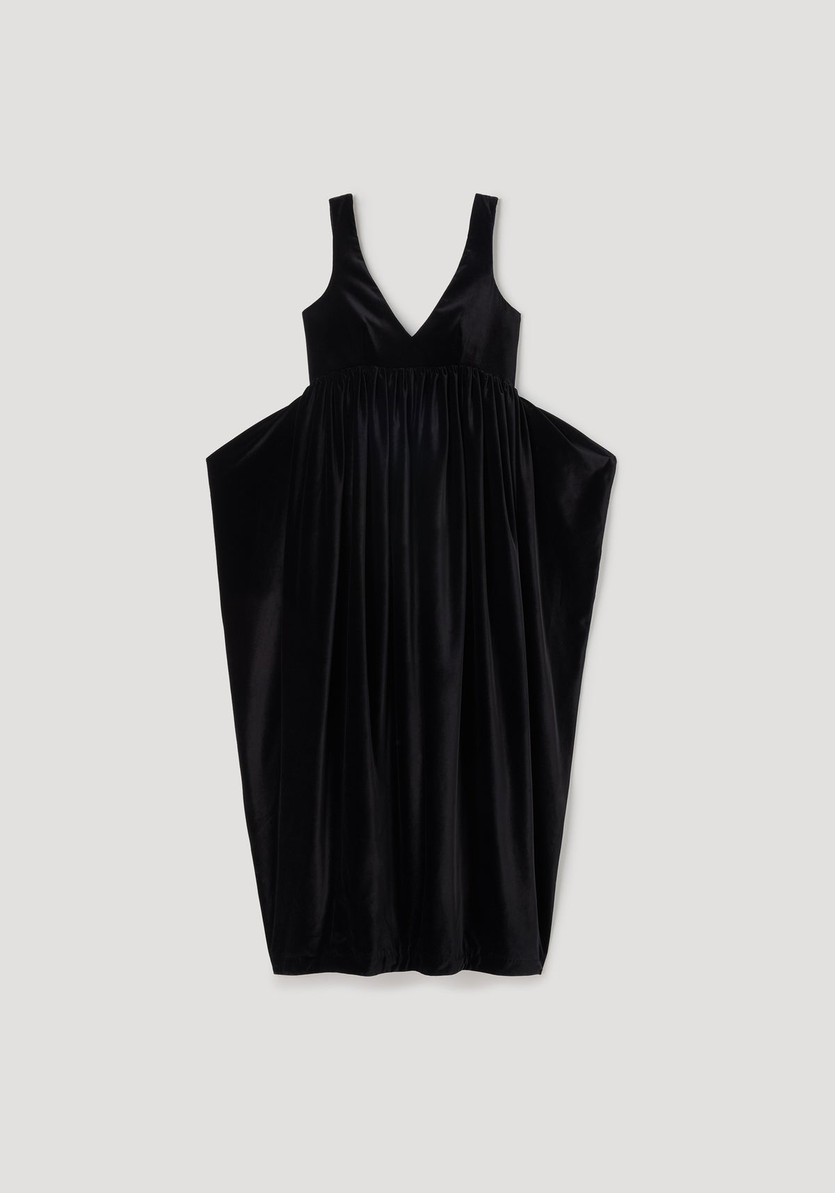 Sculptural volume velvet dress | black, sleeveless black velvet dress with a deep V neckline, gathered waist, and dramatic voluminous skirt against a neutral background