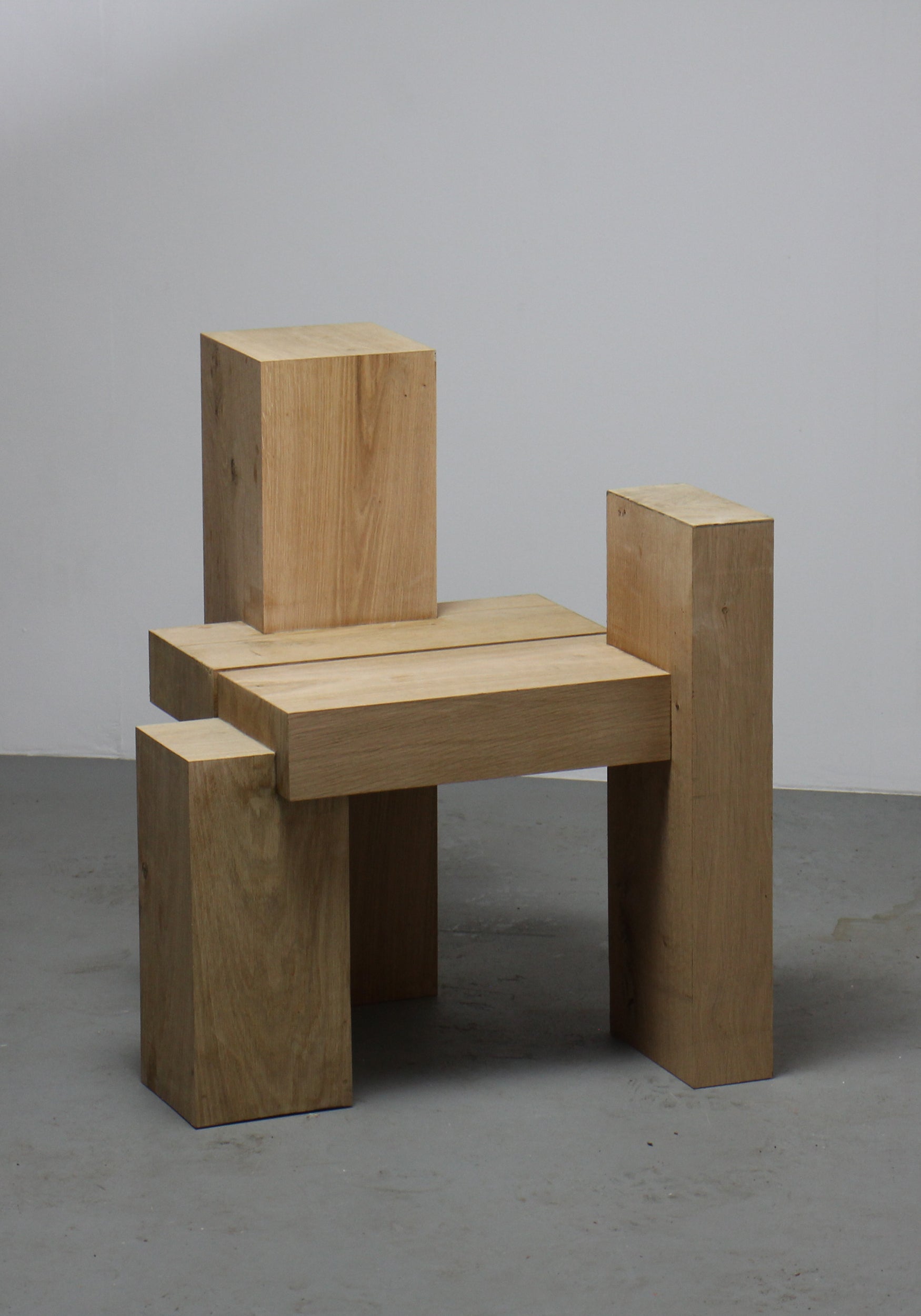 Cubistic Chair | 7365: A minimalist chair of solid oak timbers, featuring a blocky design with a low seat and rudimentary backrest, handcrafted by Arne Kristian.