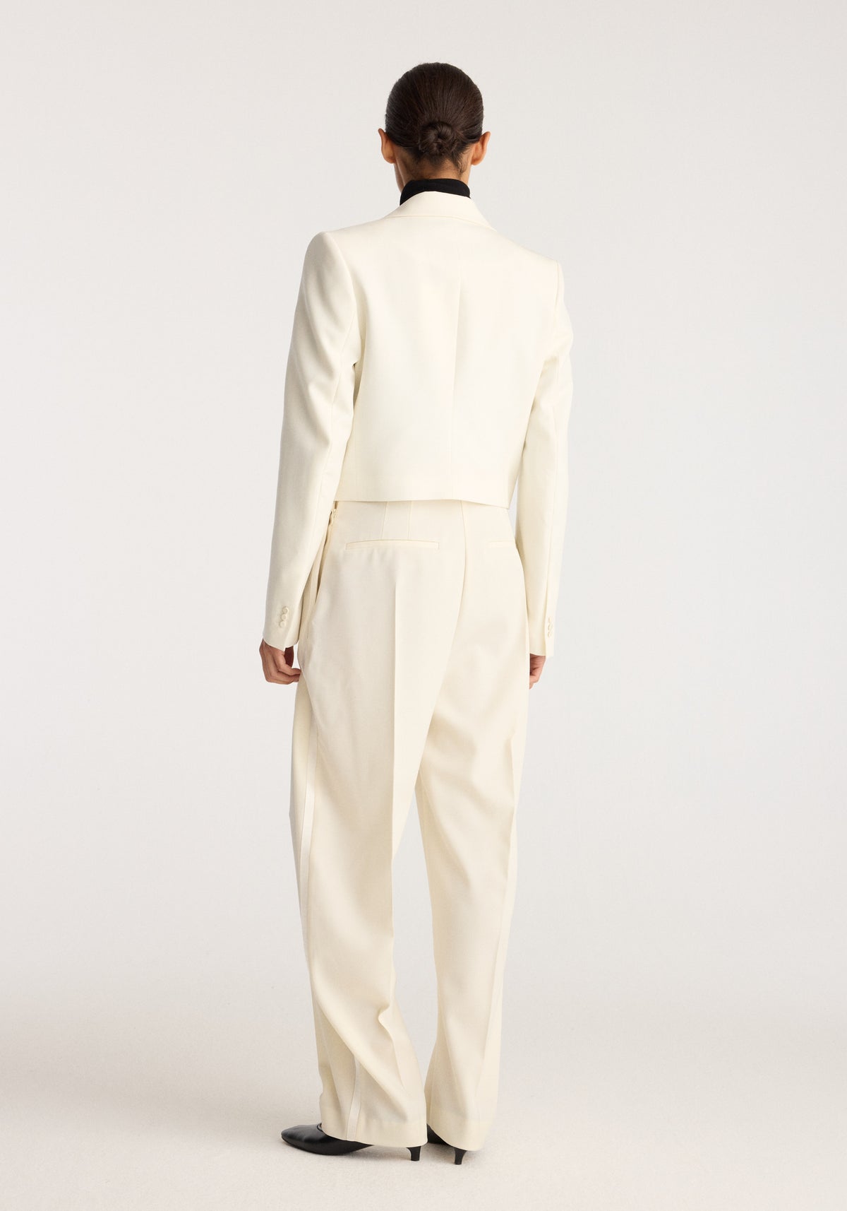 Cropped blazer | off white shown from the back on a model, featuring a tailored silhouette, long sleeves, cropped hem, and clean minimalist styling.