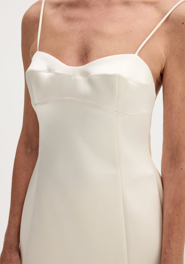 Woman wearing Satin bustier top | ivory, showcasing bustier stitching, fitted waist, adjustable straps, crafted from smooth ivory satin with subtle white seam detailing.