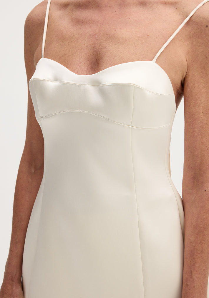 Woman wearing Satin bustier top | ivory, showcasing bustier stitching, fitted waist, adjustable straps, crafted from smooth ivory satin with subtle white seam detailing.