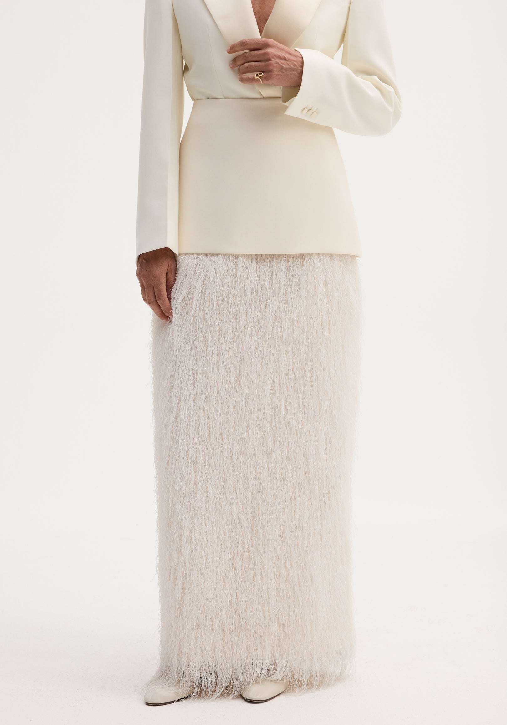 Ivory Fringe skirt with high-waist, full-length fringe detailing, and invisible zip, paired with an ivory blazer and cream pointed-toe shoes.