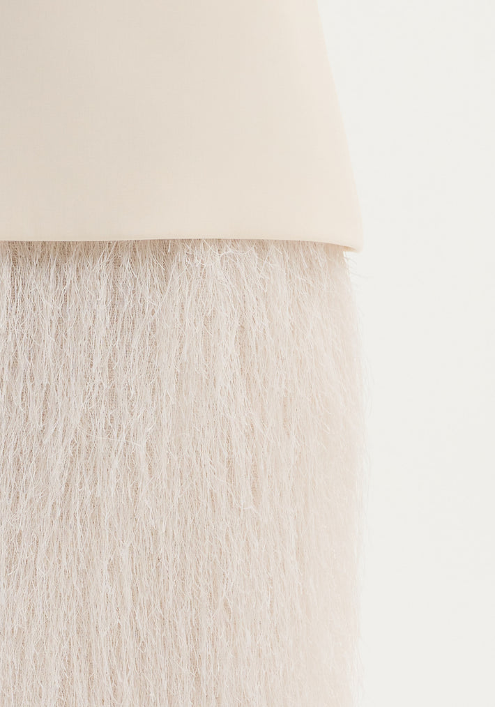 Close-up of the Fringe skirt | ivory, showcasing its smooth handle-like top and tightly packed fringe, highlighting the textured movement and structured wool blend.