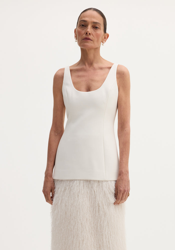 Fringe dress | ivory: A tall woman models a sleeveless, scoop-neck bodice with a long, feather-textured skirt, featuring a back slit for ease of movement.