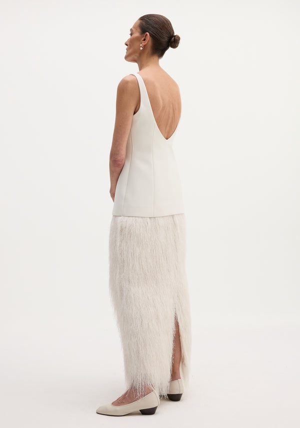 Woman in a Fringe dress | ivory, featuring a sleeveless, structured bodice and full-length fringe skirt, showcasing a deep V-back and minimalist elegance.