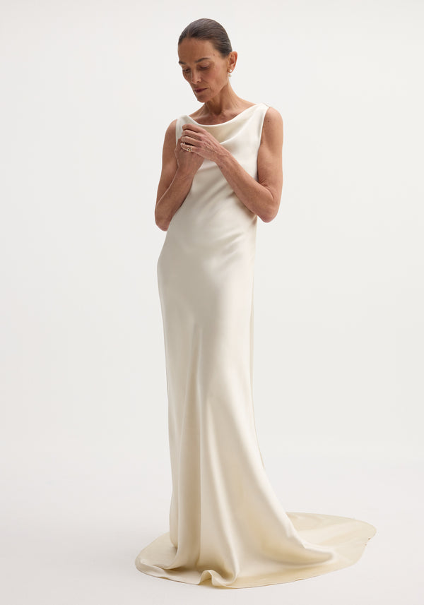 Draped satin dress with train | ivory: A sleeveless, floor-length gown with a bateau neckline, bias-cut for elegant drape, featuring a smooth column silhouette and elegant train.