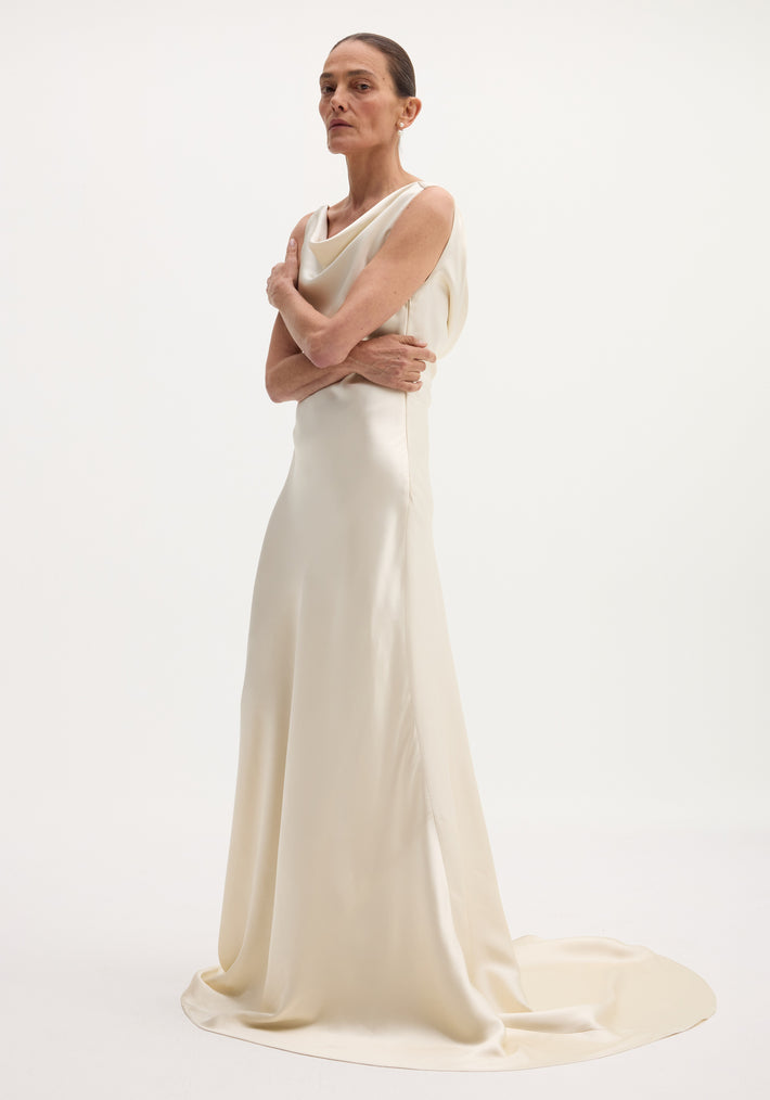 Woman in a sleeveless, ivory draped satin dress with train, featuring a cowl neckline. Hair pulled back, minimal jewelry, showcasing the Draped satin dress with train | ivory.