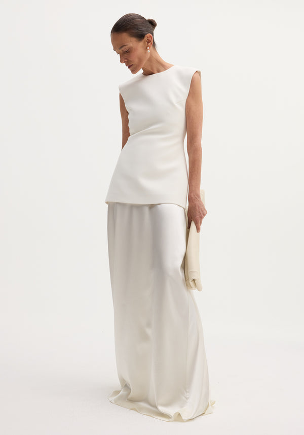 Model wearing Classic signature dress with satin silk skirt | ivory, featuring a structured bodice, open back, and flowing long skirt, holding matching fabric.