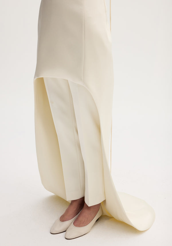 Close-up of cream wide-leg trousers and flats, layered with a tunic from the Satin bustier dress with train | ivory, emphasizing elegant, draped design.
