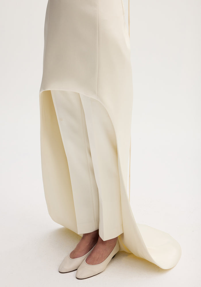 Close-up of cream wide-leg trousers and flats, layered with a tunic from the Satin bustier dress with train | ivory, emphasizing elegant, draped design.