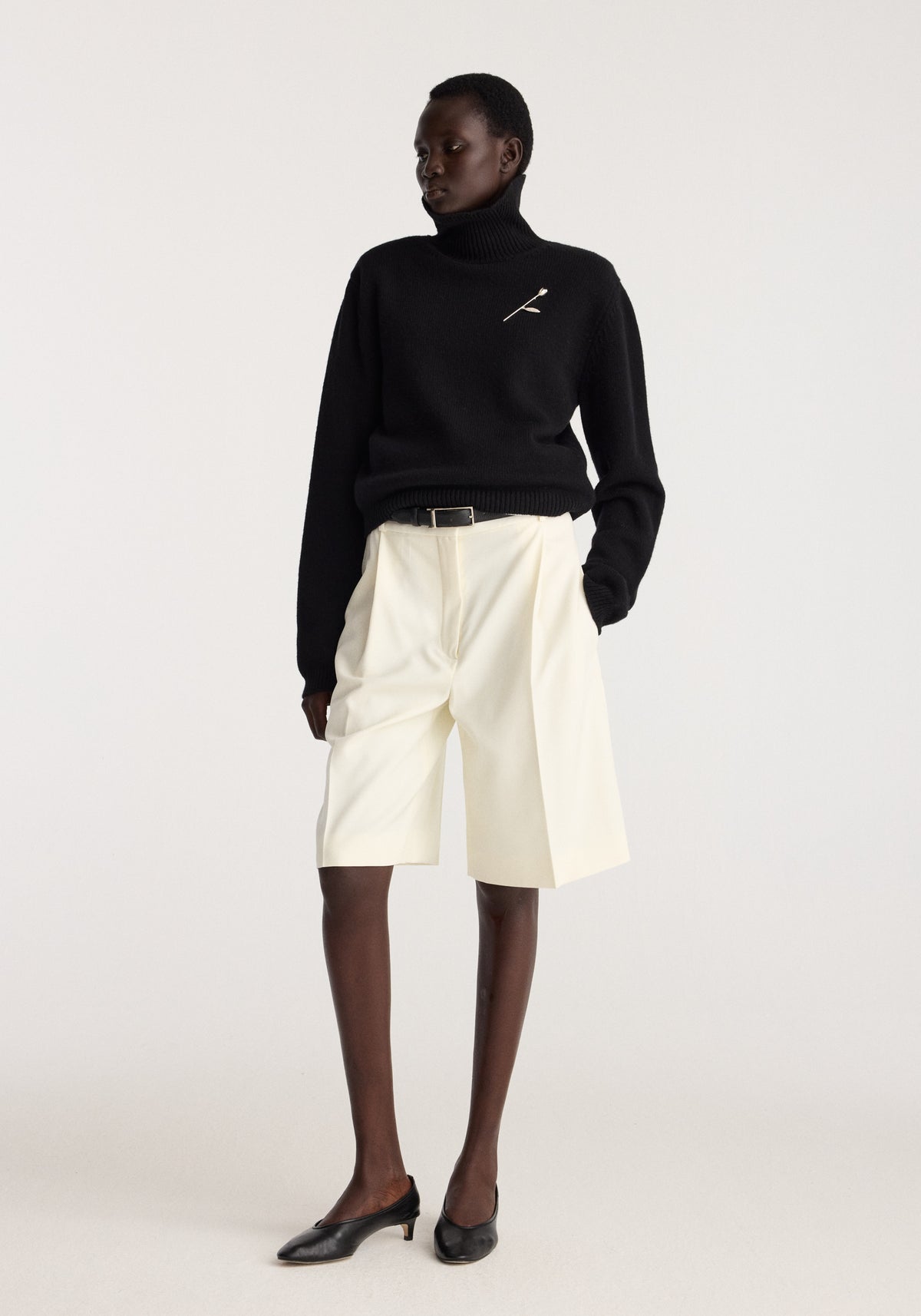 Tulip silver brooch | silver pinned to the chest of a black sweater worn by a model with cream tailored shorts and black shoes