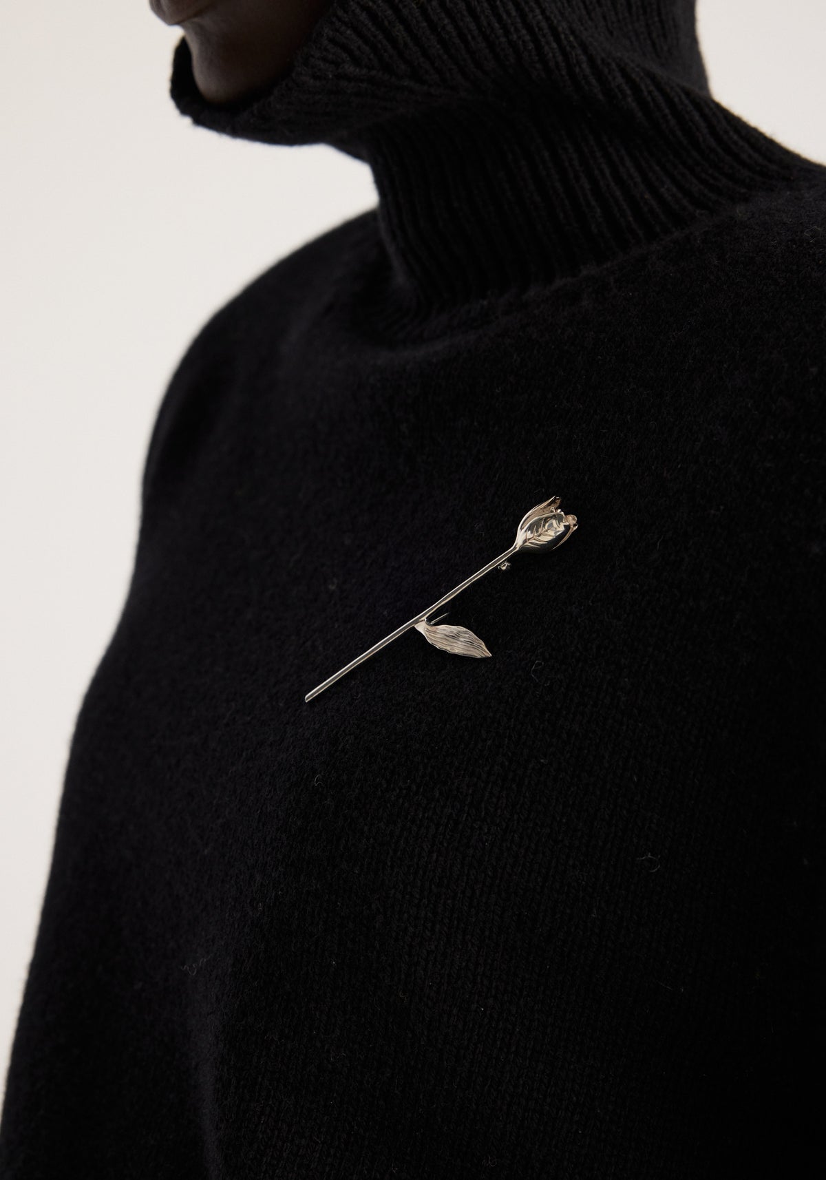 Tulip silver brooch | silver with a delicate tulip design pinned to a black knitted turtleneck sweater