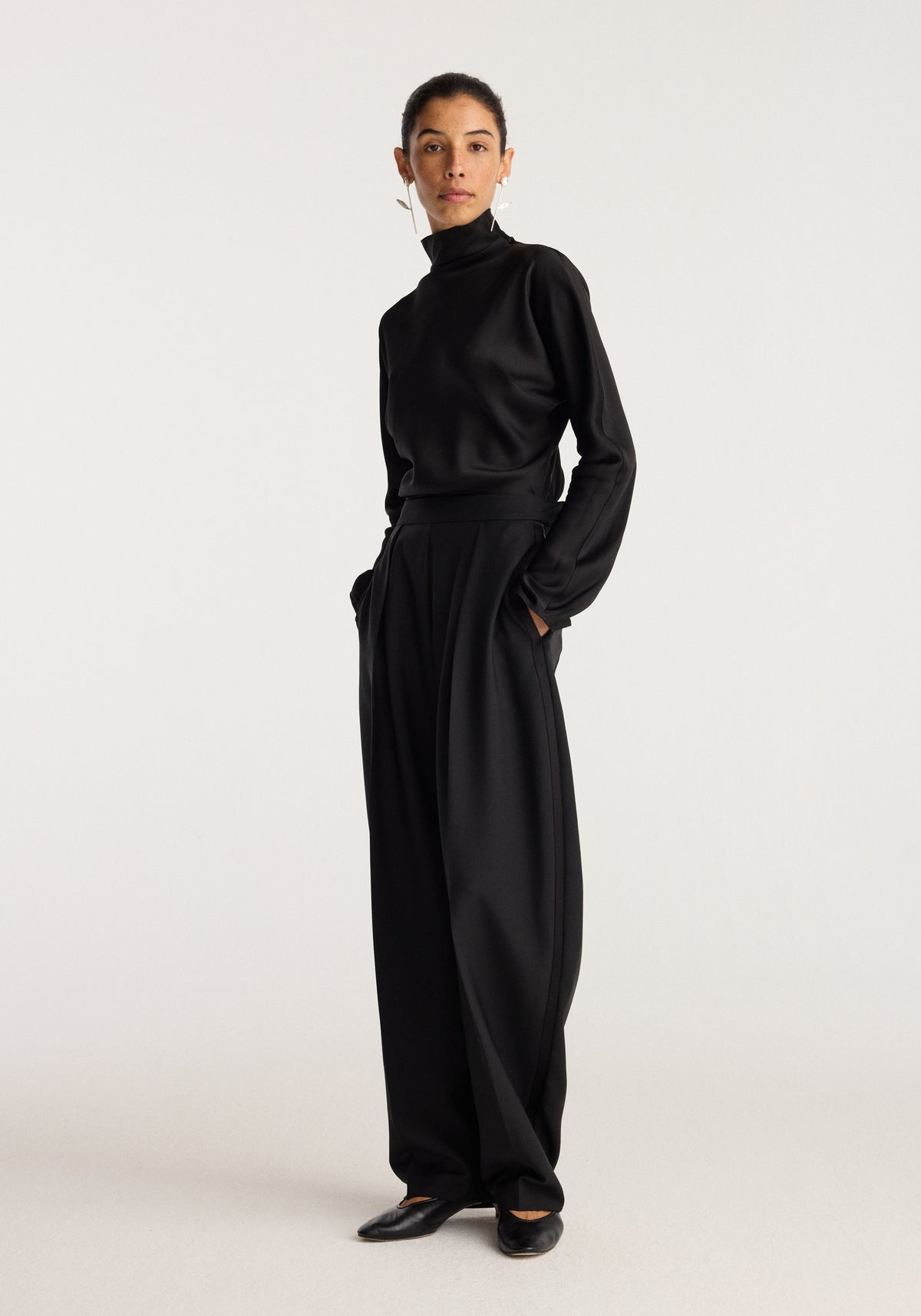 Model wearing black clothing and showcasing Tulip silver earrings (pair) | silver against a neutral studio background