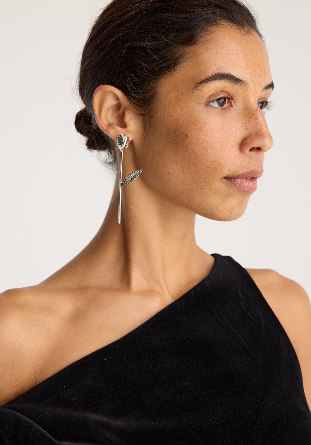 Tulip silver earring (single) | silver shown on a woman as a delicate dangling floral earring with a tulip shaped top and slender drop