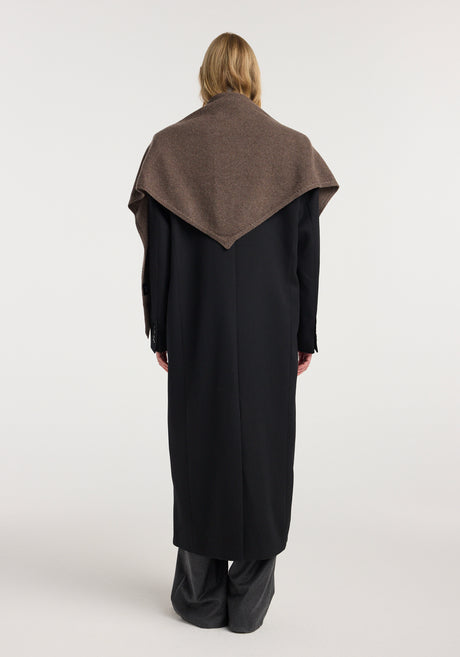 Woman wearing a black long coat over a gray turtleneck and trousers, with a Large knitted triangle scarf | brown melange draped over her shoulders.