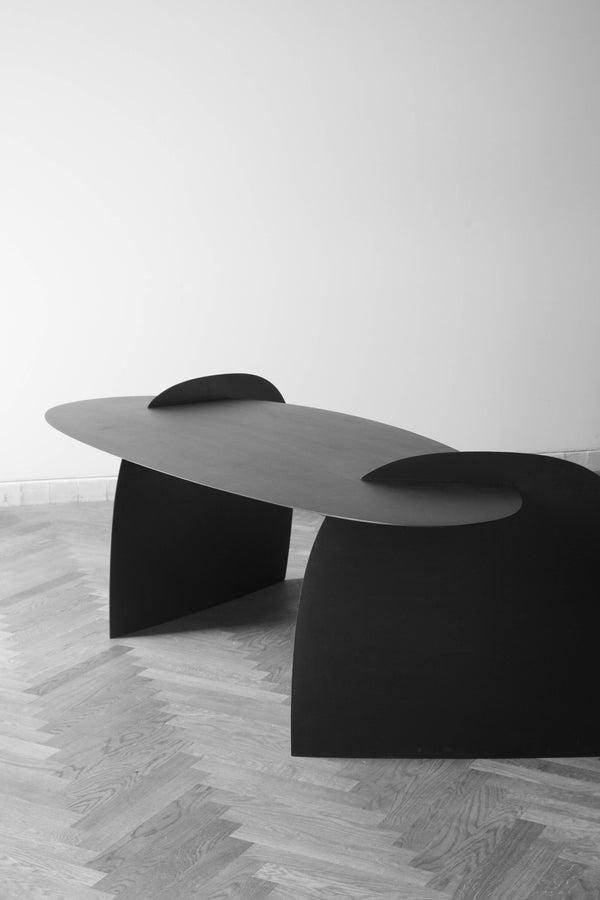 Sculpted Table | 9845: A low, oval-shaped table with fin-like tabs, crafted from oak by Arne Kristian, resting on arched supports in a minimalist setting.