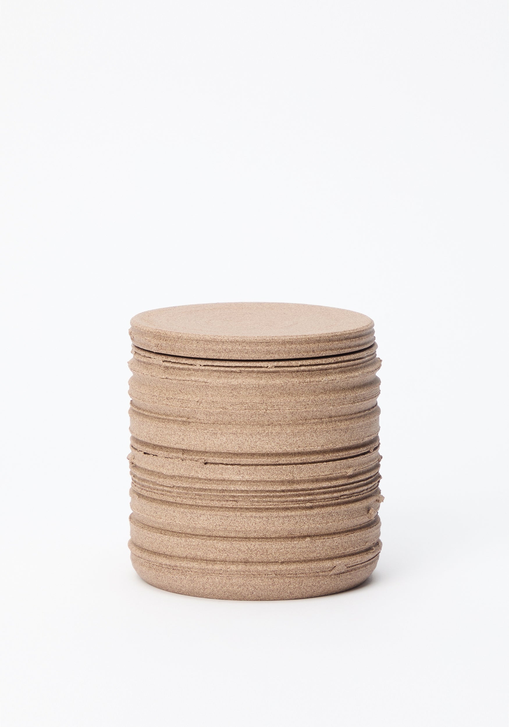 Diplomatico Scented Candle | clay in a textured, cylindrical clay container with horizontal ridges and a matching flat lid, displayed against a white background.