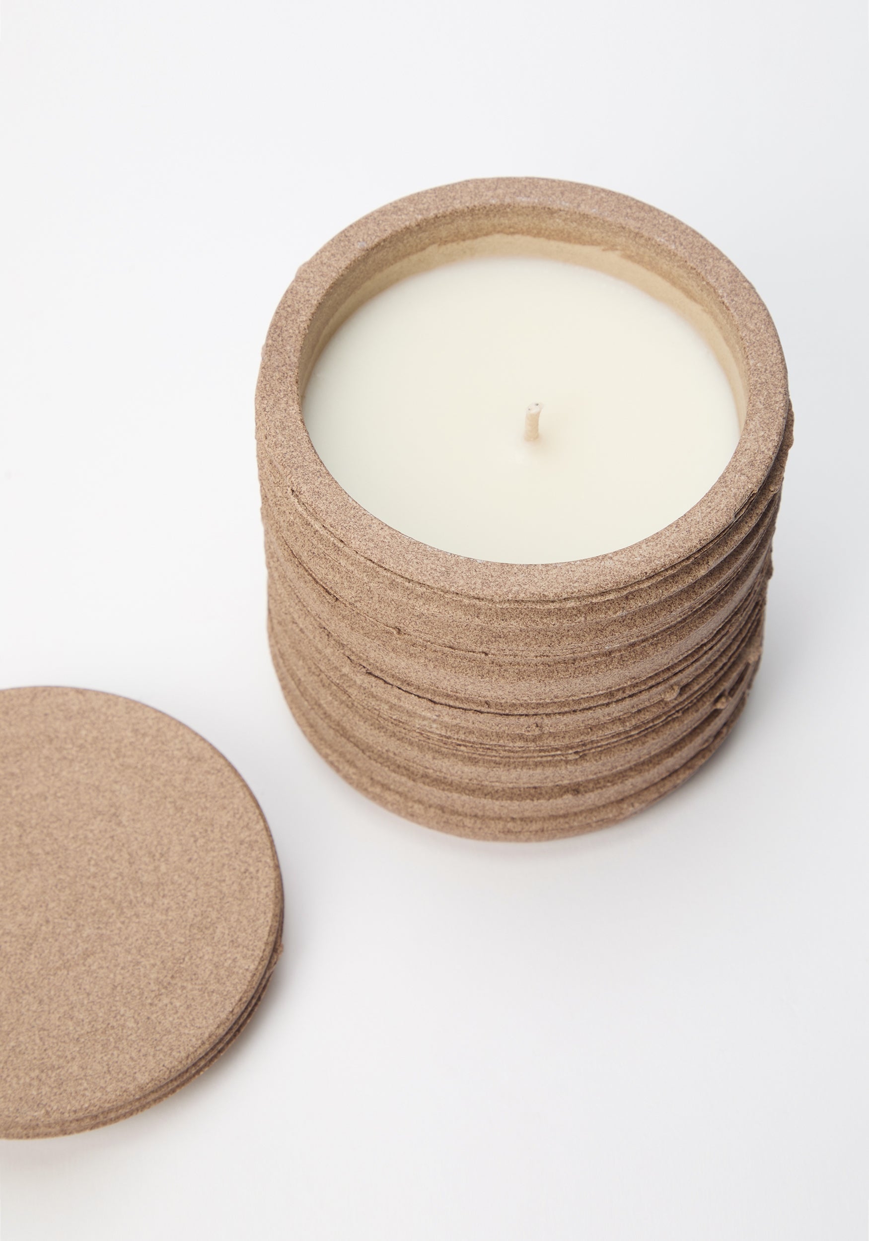 Diplomatico Scented Candle | clay with a textured, cylindrical clay container and matching lid, featuring smooth white wax and a single wick, displayed on a white background.