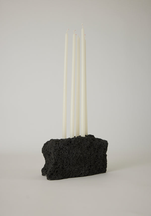 Sculptural Stone Candle Holder with six white taper candles set in a handcrafted black lava stone block, showcasing minimalist design by Dutch artist Louis Crombag.