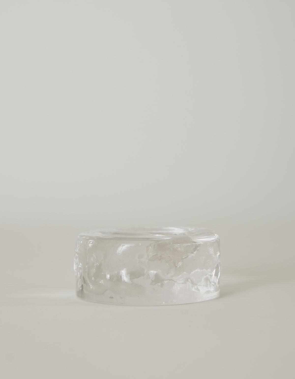 Presse-papier & holder by Szkło Studio: A clear, rippled, glass-like cylinder, showcasing handcrafted, unique design with a raw, crystalline appearance.