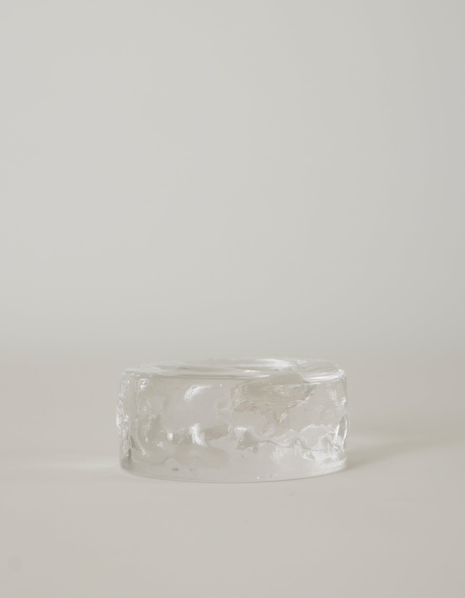 Presse-papier & holder by Szkło Studio: A clear, rippled, glass-like cylinder, showcasing handcrafted, unique design with a raw, crystalline appearance.