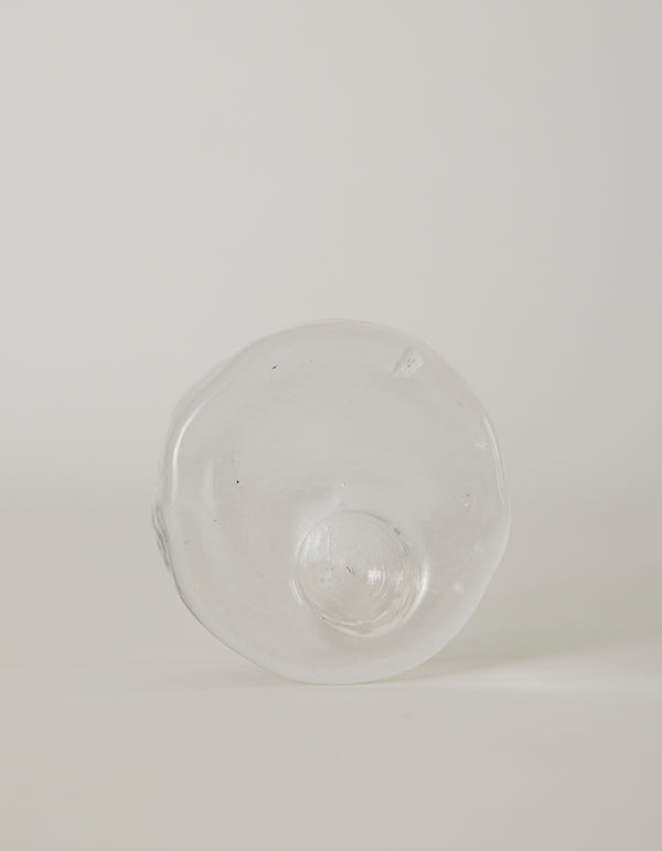 Presse-papier & holder | Glass: Hand-blown clear glass with an irregular circular shape and central dome, featuring ripples and imperfections, highlighting unique craftsmanship.