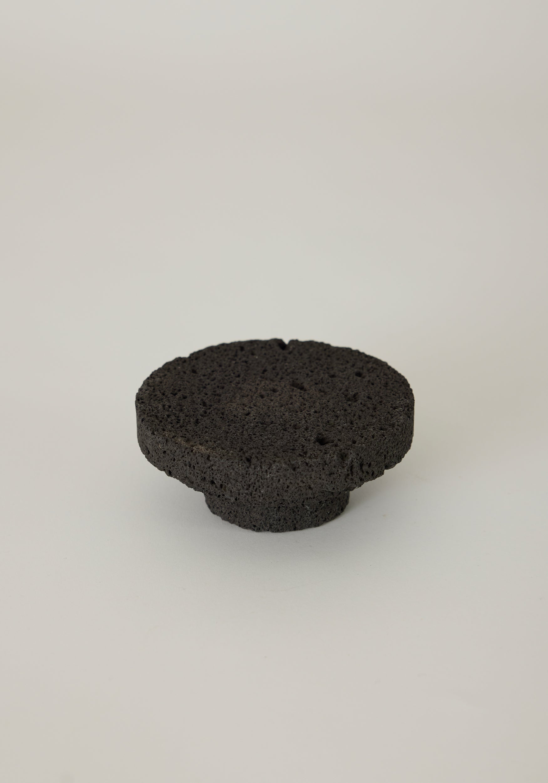 Elevated Sculptural Tray crafted from lava stone, featuring a porous texture with a circular design and smaller base, handcrafted by Louis Crombag in the Netherlands.