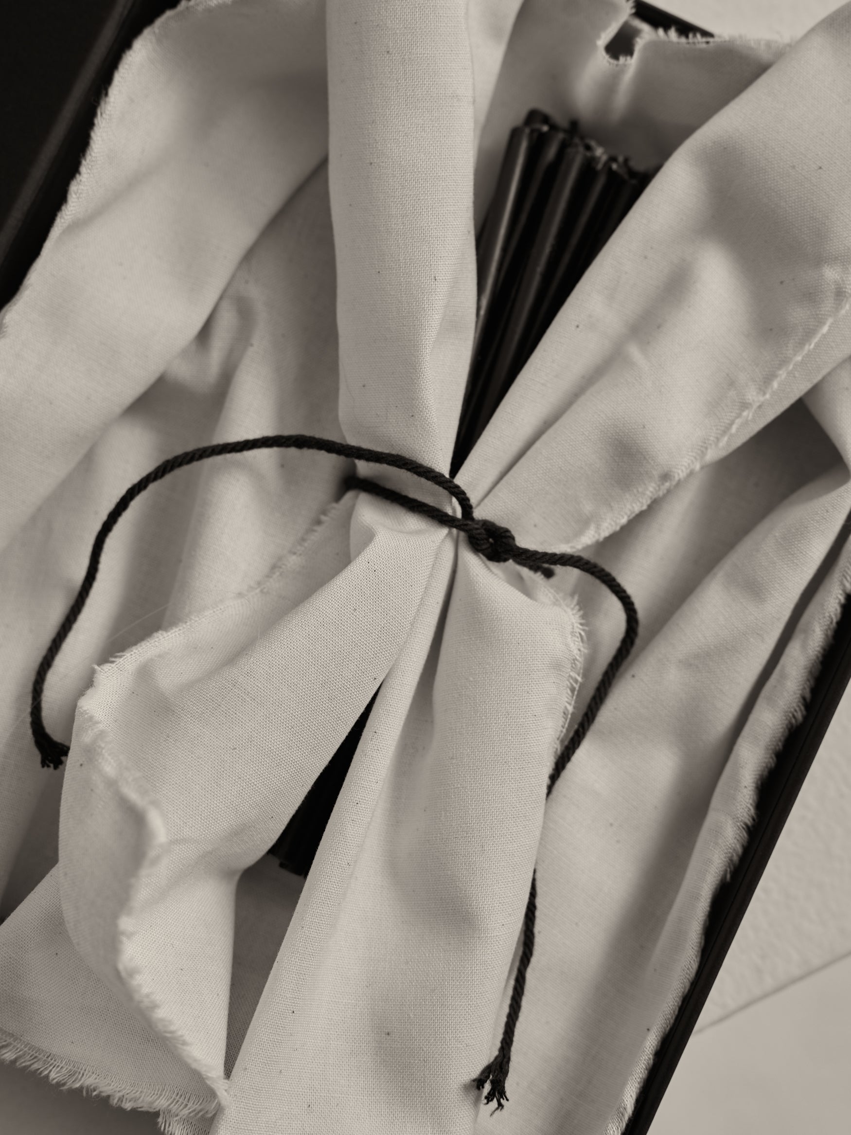 Candles 10mm | noir black candles bundled with a black string, set inside a white fabric-lined box.
