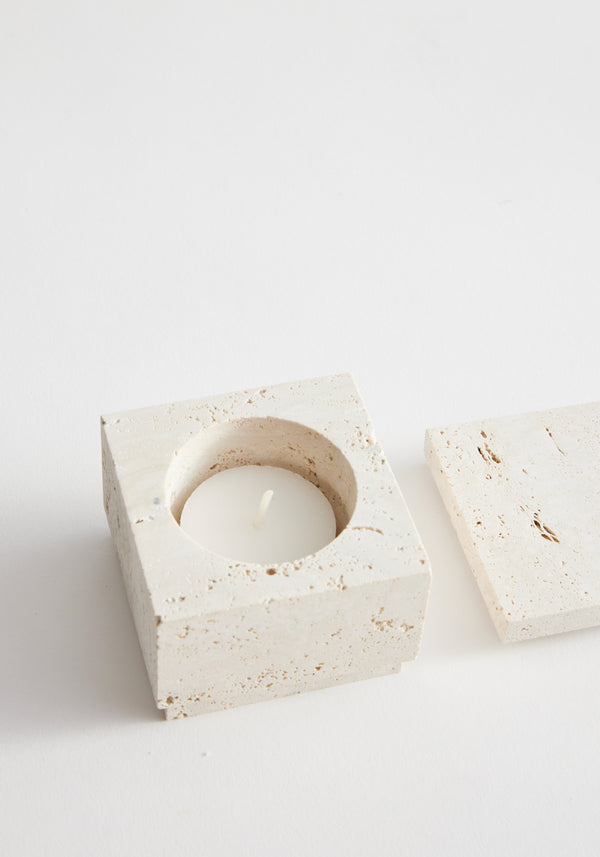 Tealight box | travertine: A small, square travertine container with a hollow center for a tealight, accompanied by a matching lid. Handcrafted by Louis Crombag.
