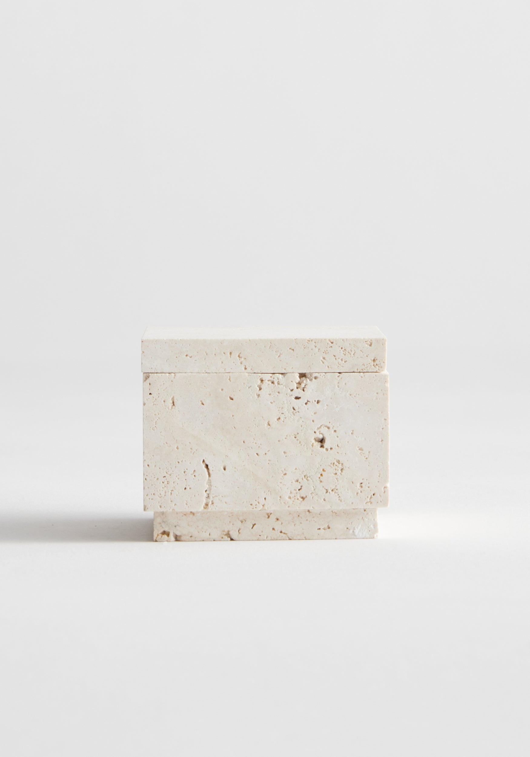 Tealight box | travertine: A small, handcrafted travertine box with lid, showcasing natural texture and pitting, designed for tealight or versatile use, on a white background.