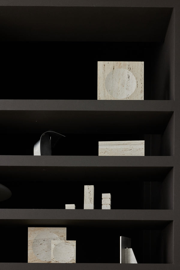 Medium tray | travertine displayed on a dark shelf with minimalistic stone and metal accents, showcasing its handcrafted design and unique circular indent.