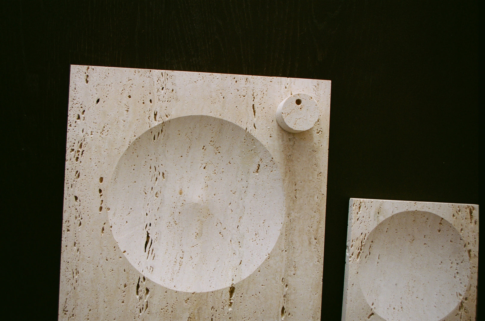 Small tray | travertine: Two travertine panels with circular recesses, handcrafted by Louis Crombag, showcasing unique indent designs from leftover Italian stone.