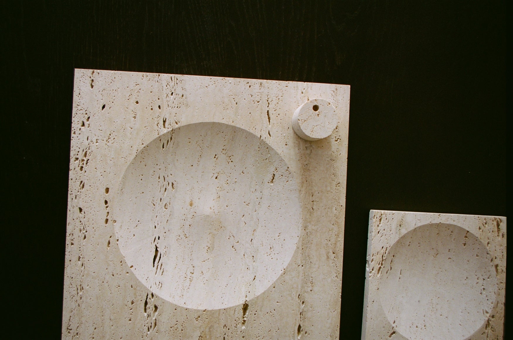 Large tray | travertine: Rectangular stone slab with circular recess, includes decorative cylinder for candles. Handcrafted in the Netherlands from Italian travertine.