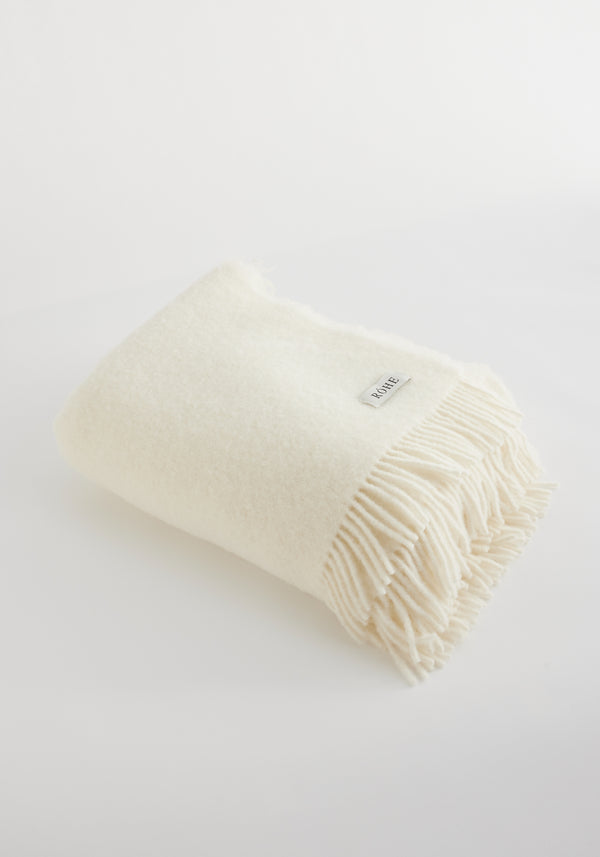 Cream Wool blanket with chunky fringes, showcasing a RÖHE. label. Made from 80% virgin wool, 20% polyamide, measuring 130cm x 180cm.