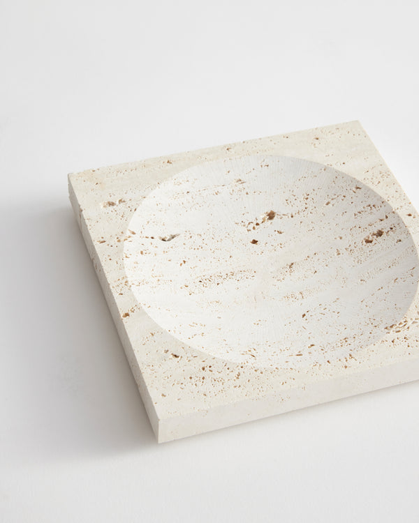 Small tray | travertine featuring a square shape with a circular indent, showcasing natural pitting and veining, handcrafted by Louis Crombag from leftover travertine.