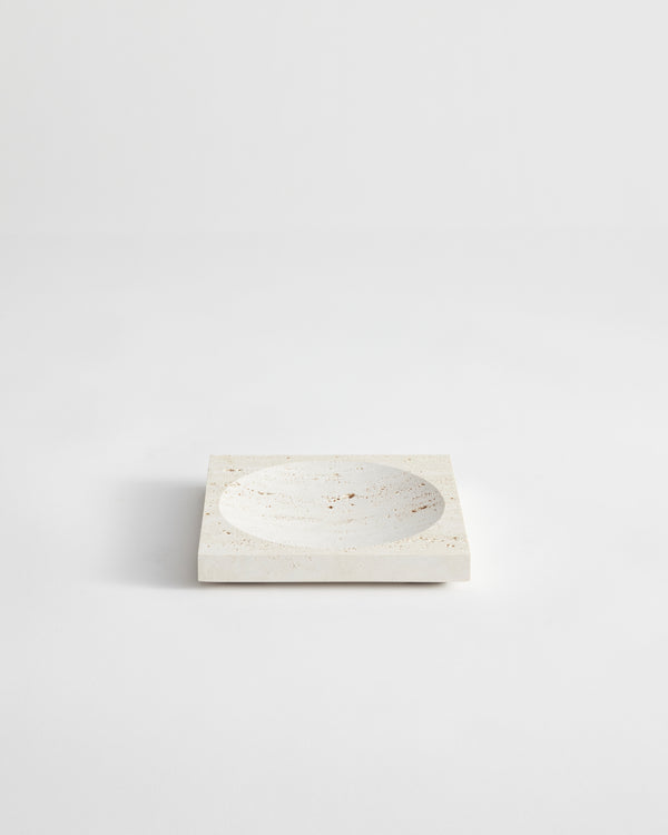 Small tray | travertine: A square stone tray with a central circular depression, handcrafted from speckled travertine, measuring 16cm by 16cm, designed by Louis Crombag.