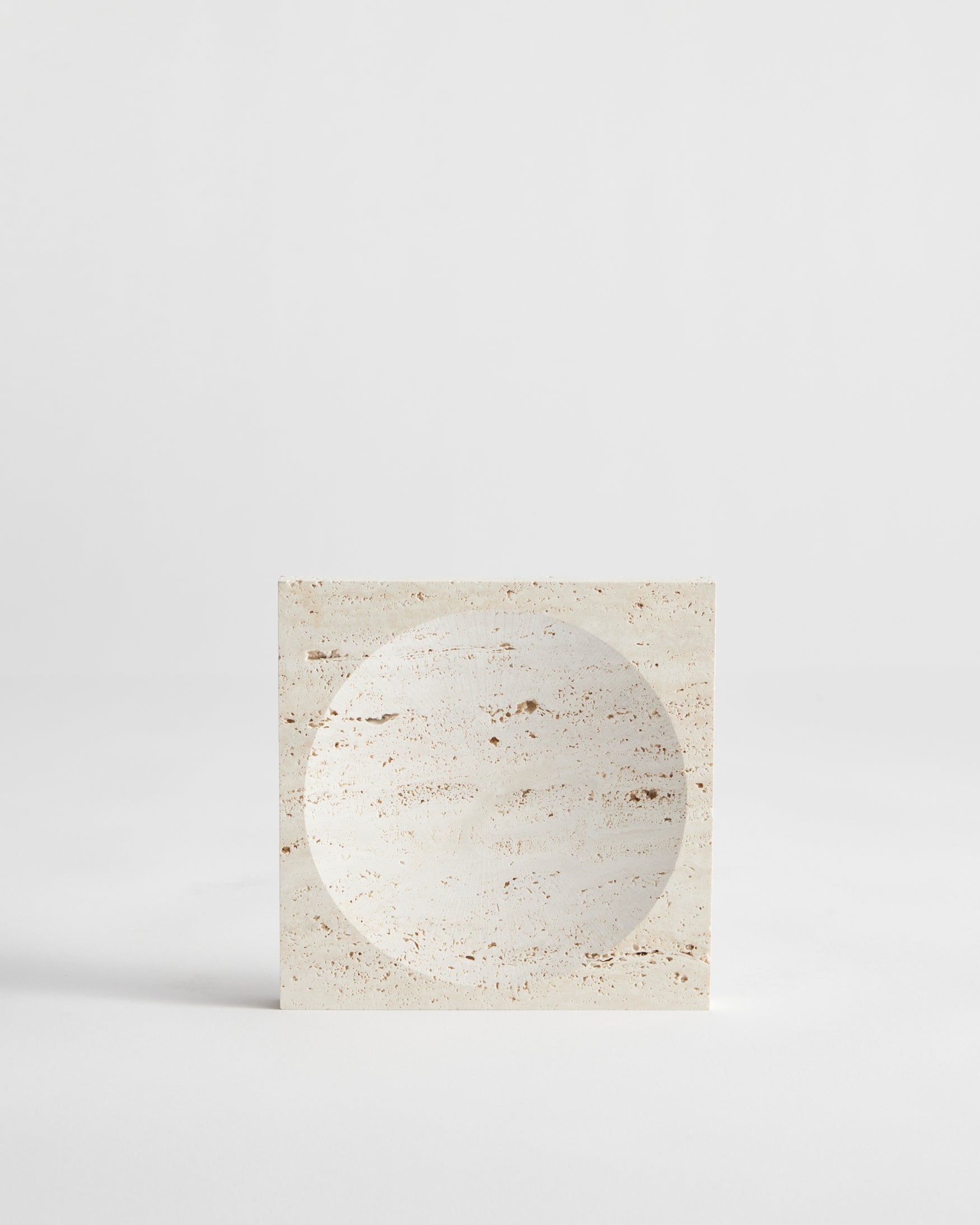 Small tray | travertine: A handcrafted square travertine tray with a circular indent, showcasing minimalist design. Created by Dutch artist Louis Crombag.