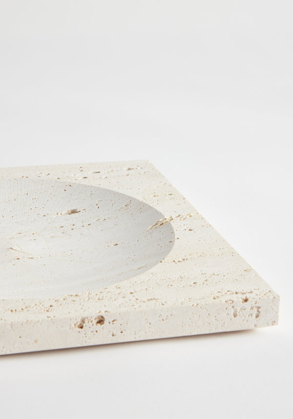 Medium tray | travertine: Square tray with a circular indent, handcrafted from leftover Italian travertine by Louis Crombag, showcasing minimalist design against a plain background.