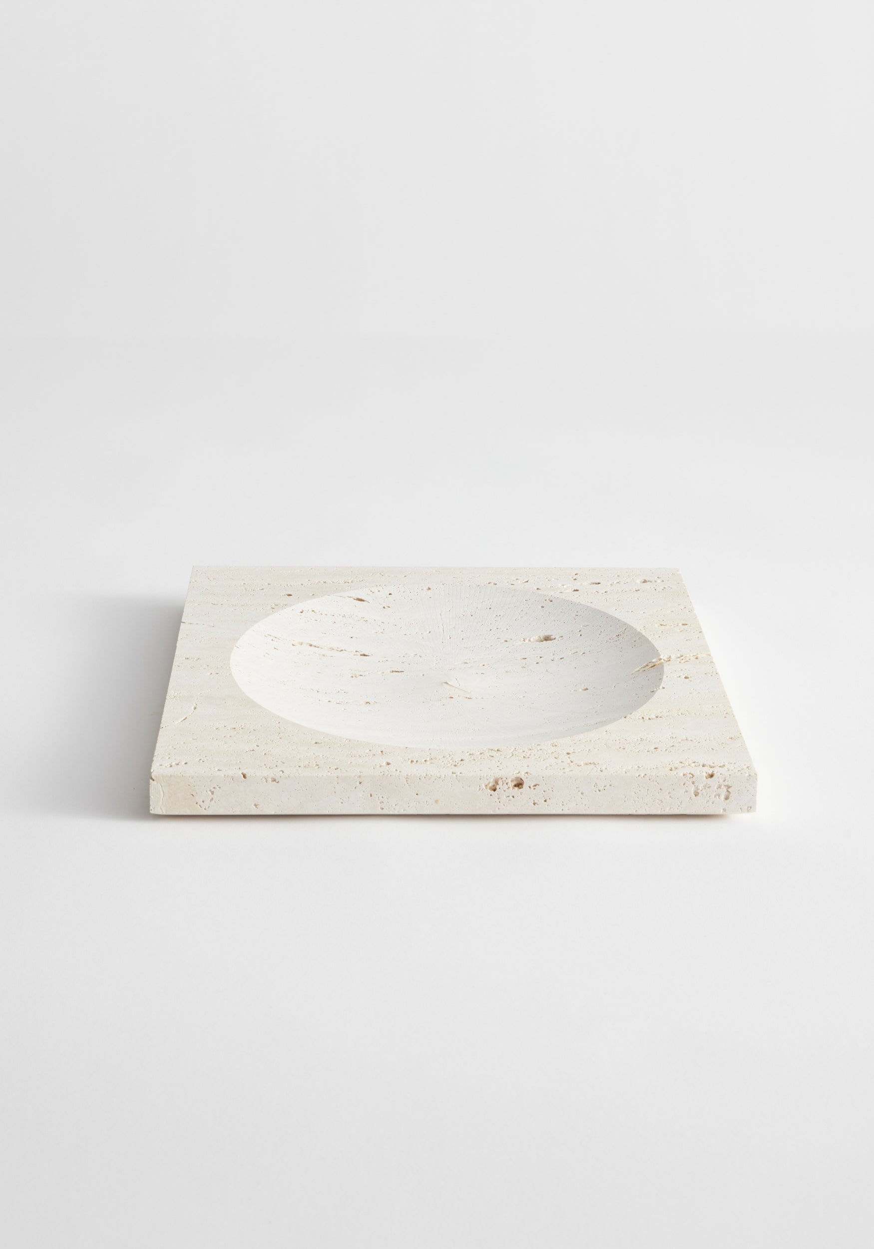 Medium tray | travertine with smooth, shallow bowl design in natural light beige stone, showcasing subtle textured patterns and clean, minimalist edges on a white background.